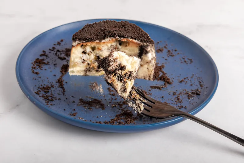 Cheesecake individual de galleta de chocolate abierto mostrando el relleno cremoso