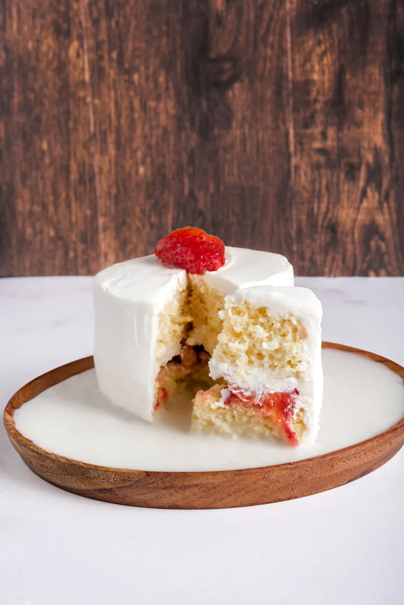 Corte de pastel de tres leches individual mostrando capas y relleno de fresa