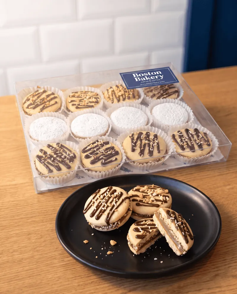 Caja de doce galletas de Boston Bakery empacada junto a galletas servidas en plato negro